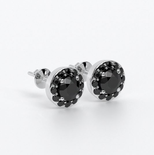 Pendientes de oro de 18k con un diamante negro central en talla brillante rodeado por un halo de diamantes negros, con un total de 3cts