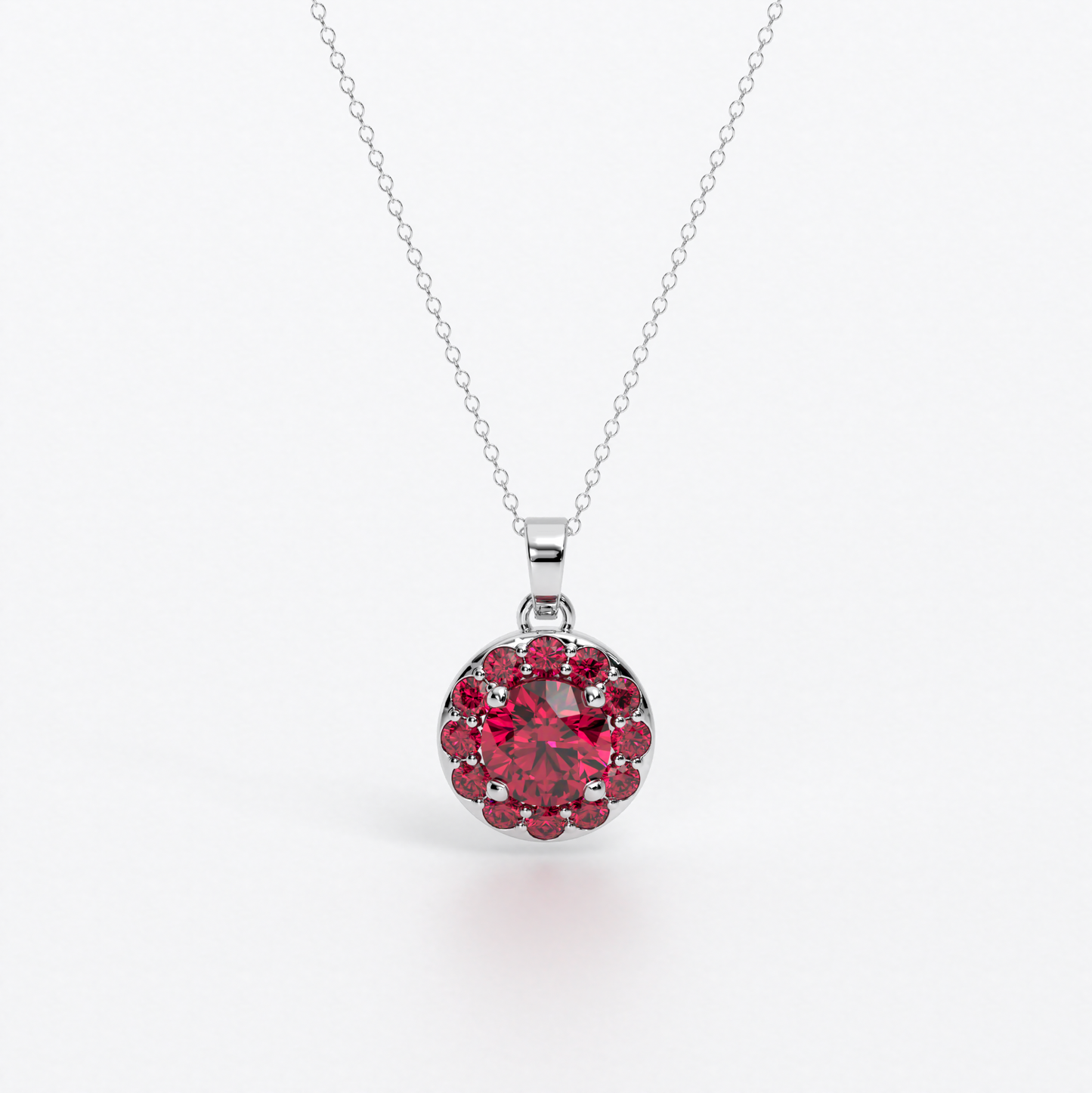 Colgante de oro de 18k con rubí central en talla brillante, rodeada por un halo de rubies, con un total de 2cts