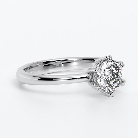 Solitario de oro blanco 18k con un diamante en talla brillante central de 0,4 con seis grapas