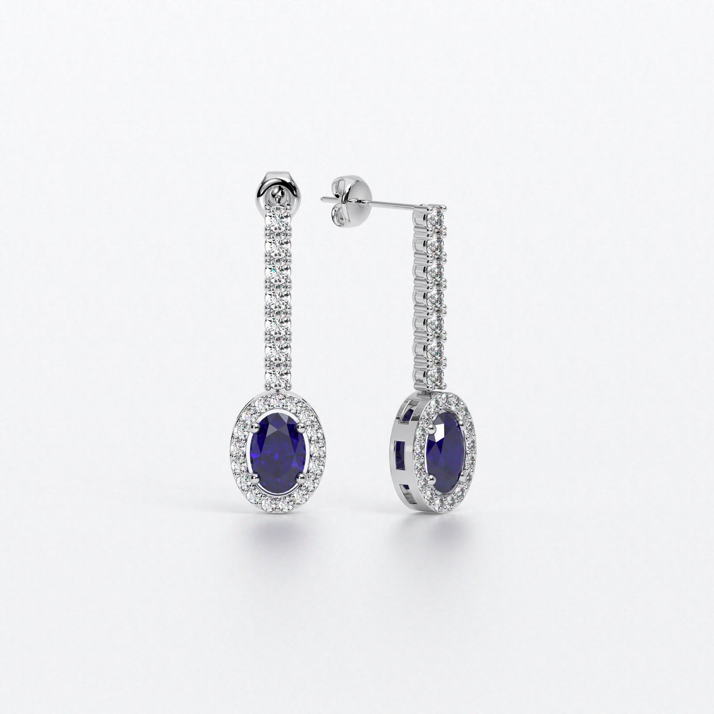 Pendientes largos en oro blanco con zafiros ovales con halo de diamantes y línea superior de diamantes