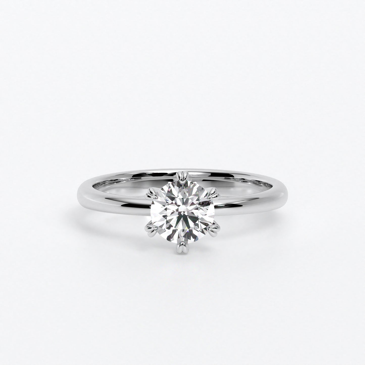 Solitario de oro blanco 18k con un diamante en talla brillante central de 0,4 con seis grapas