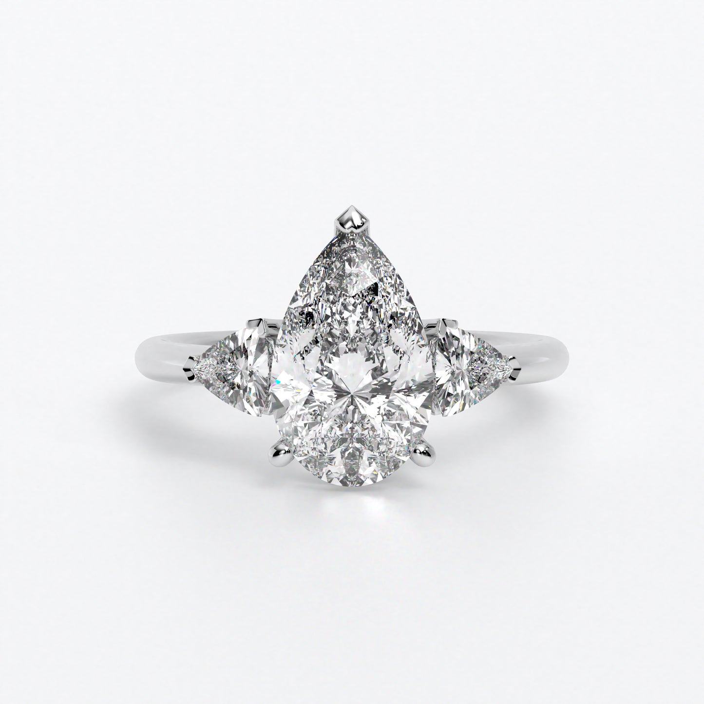 Anillo de oro blanco de 18K con diamante central en talla Pera , 2 diamantes en talla triángulo