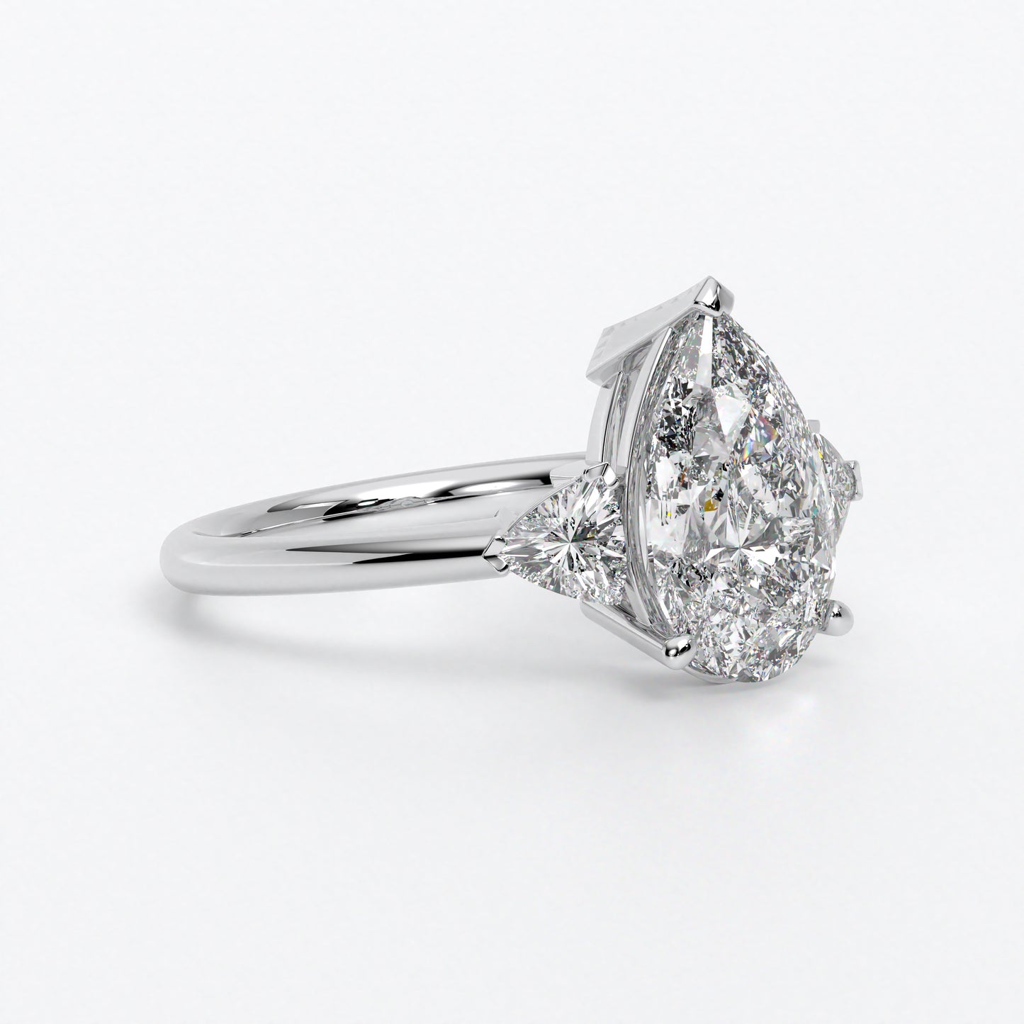Anillo de oro blanco de 18K con diamante central en talla Pera , 2 diamantes en talla triángulo