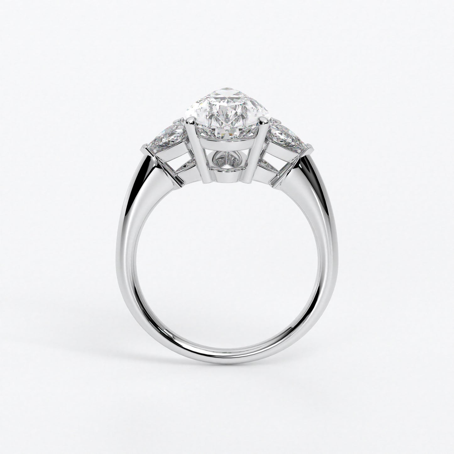 Anillo de oro blanco de 18K con diamante central en talla Pera , 2 diamantes en talla triángulo