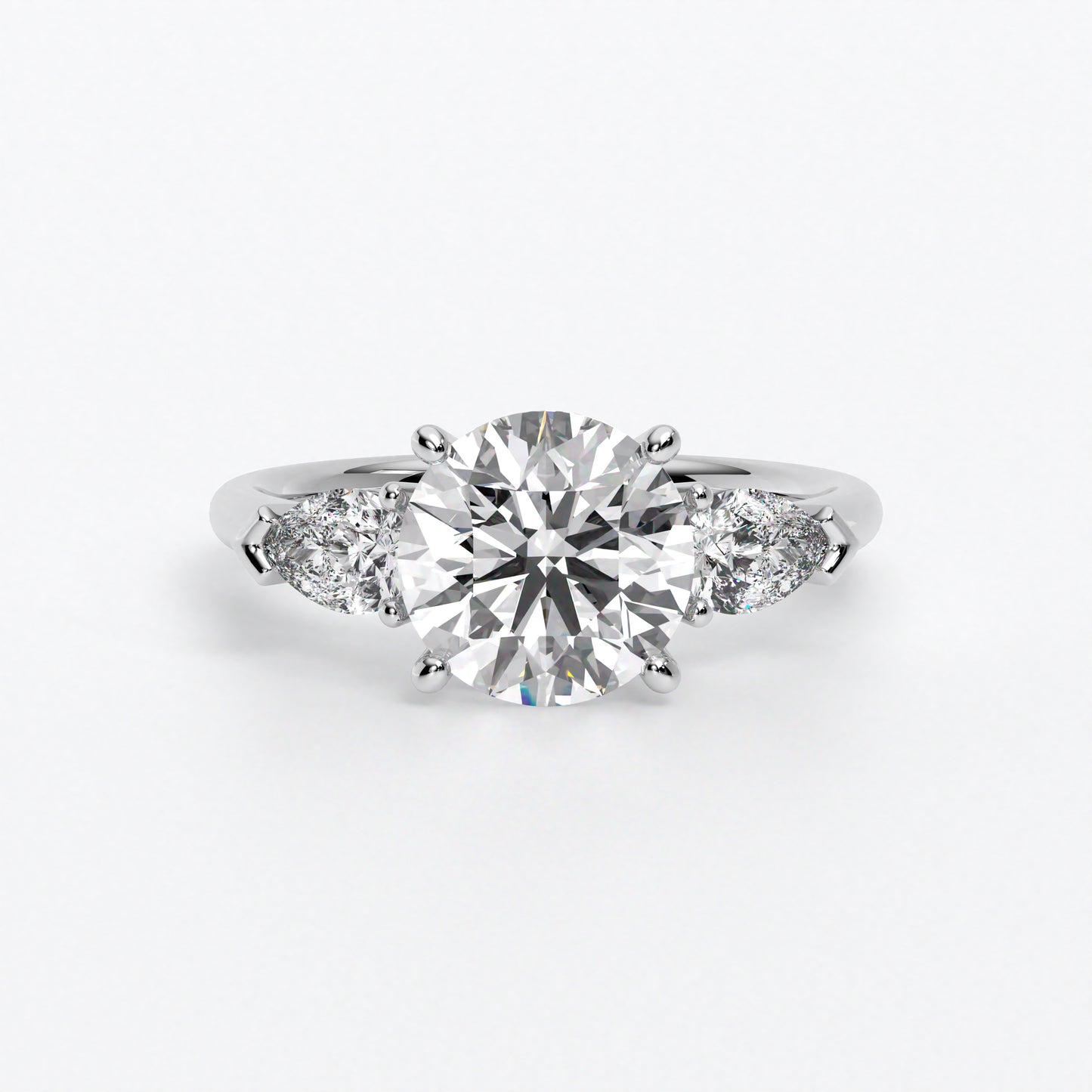 Anillo de oro blanco de 18K con diamante central en talla brillante, 2 diamantes en talla pera