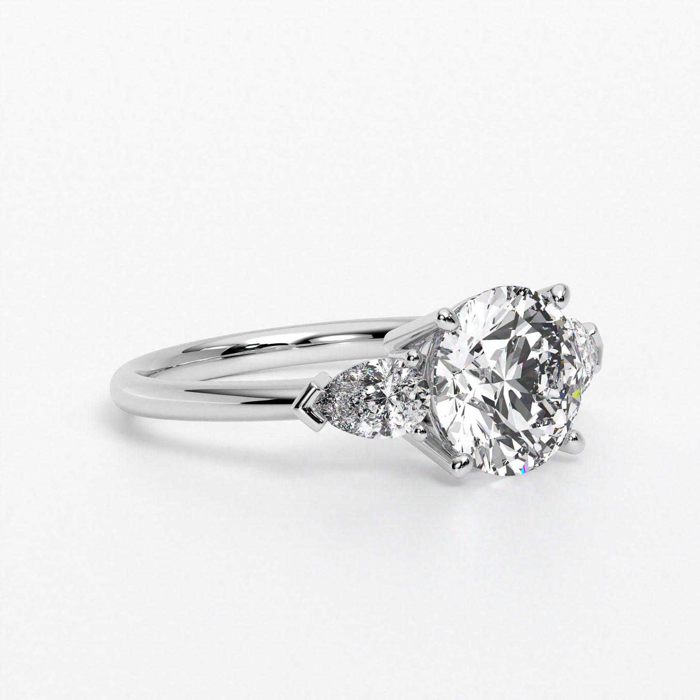 Anillo de oro blanco de 18K con diamante central en talla brillante, 2 diamantes en talla pera