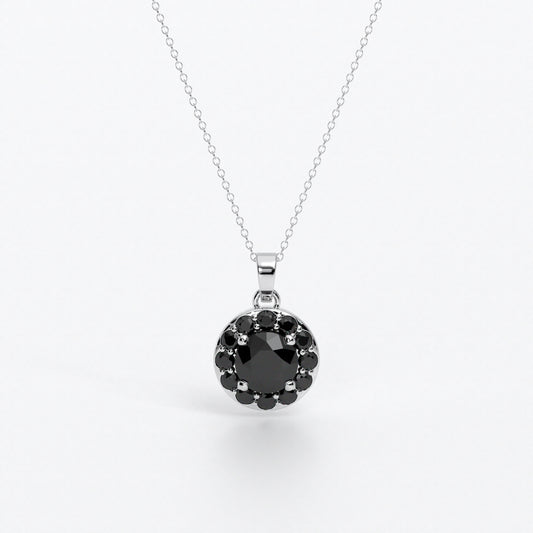 Colgante de oro de 18k con diamante negro central en talla brillante, rodeada por un halo de diamantes negros, con un total de 1,1cts
