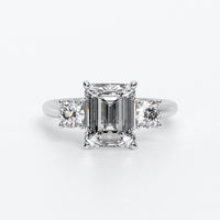 Anillo de oro blanco de 18K con diamante central en talla Esmeralda, 2 diamantes en talla brillante