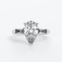 Anillo de oro blanco de 18K con diamante central en talla pera, 2 diamantes en talla trapecio