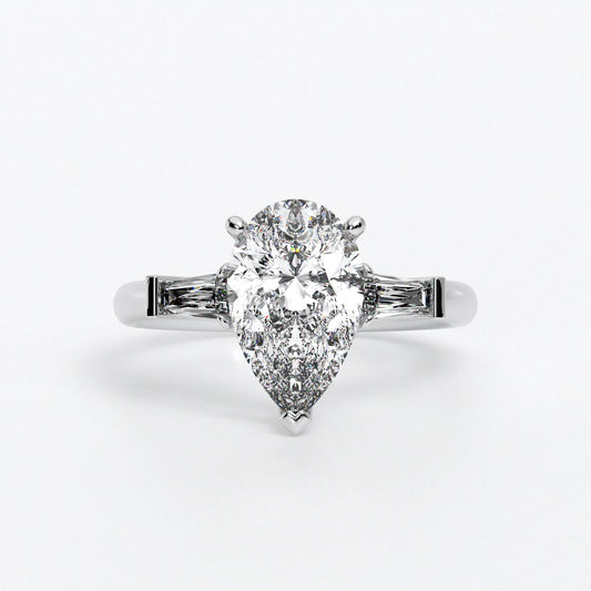 Anillo de oro blanco de 18K con diamante central en talla pera, 2 diamantes en talla trapecio
