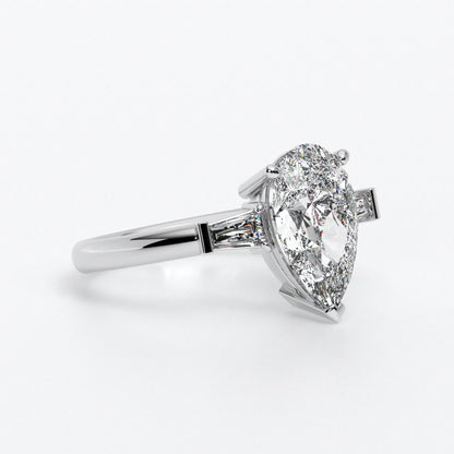 Anillo de oro blanco de 18K con diamante central en talla pera, 2 diamantes en talla trapecio