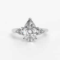 Anillo de oro blanco de 18K con diamante central en talla Pera , 2 diamantes en talla triángulo