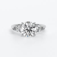 Anillo de oro blanco de 18K con diamante central en talla brillante, 2 diamantes en talla pera