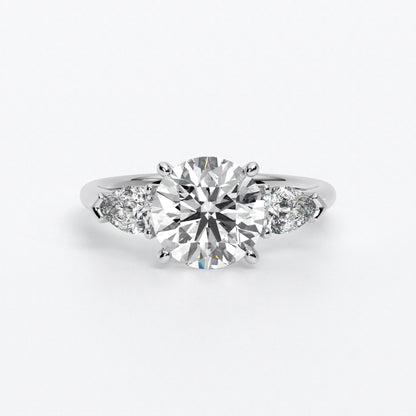 Anillo de oro blanco de 18K con diamante central en talla brillante, 2 diamantes en talla pera