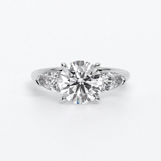 Anillo de oro blanco de 18K con diamante central en talla brillante, 2 diamantes en talla pera
