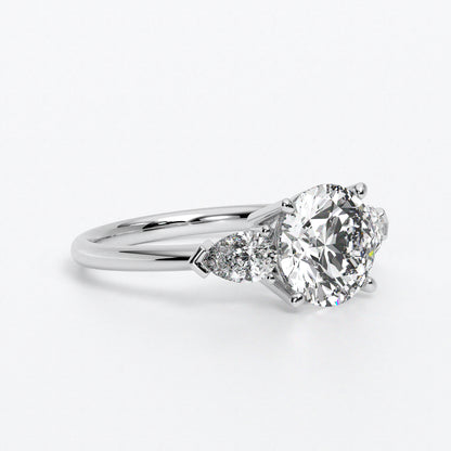 Anillo de oro blanco de 18K con diamante central en talla brillante, 2 diamantes en talla pera