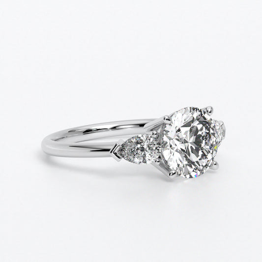 Anillo de oro blanco de 18K con diamante central en talla brillante, 2 diamantes en talla pera