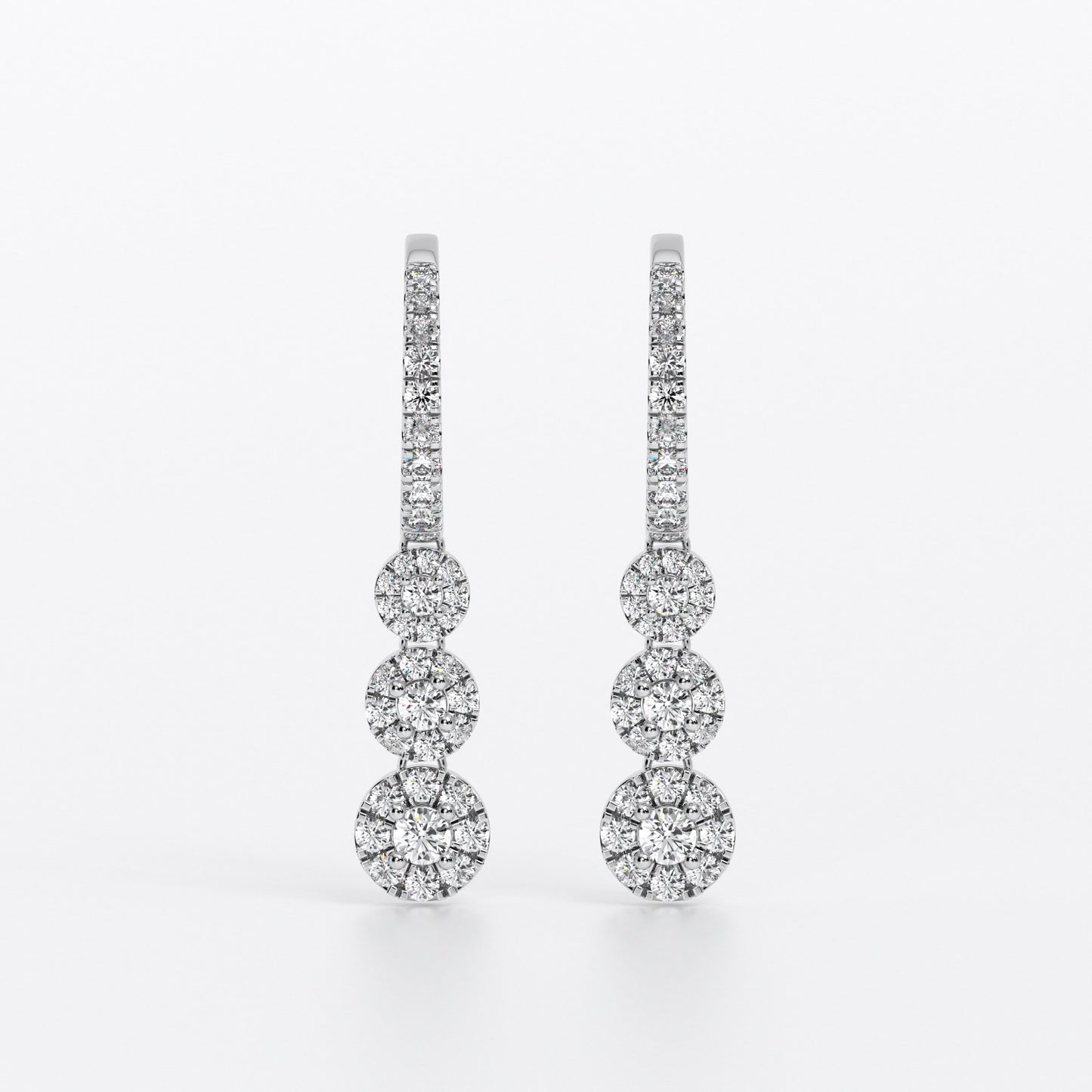 Pendientes largos de oro blanco con tres rosetones de diamantes en degradé