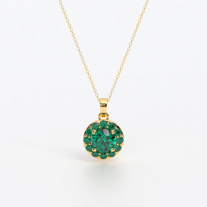 Colgante de oro de 18k con esmeralda central en talla brillante, rodeada por un halo de esmeraldas, con un total de 2cts