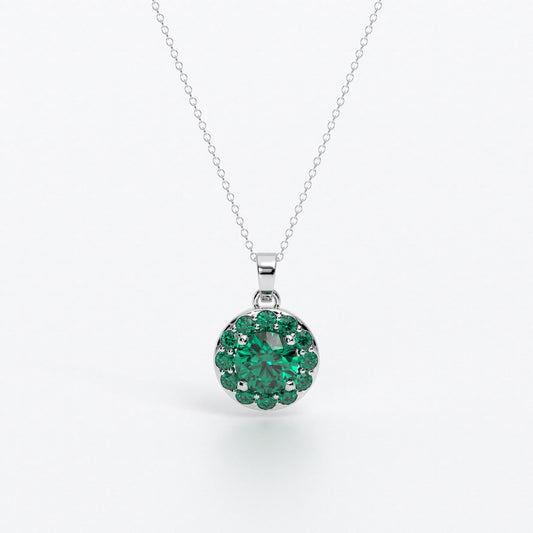 Colgante de oro de 18k con esmeralda central en talla brillante, rodeada por un halo de esmeraldas, con un total de 2cts